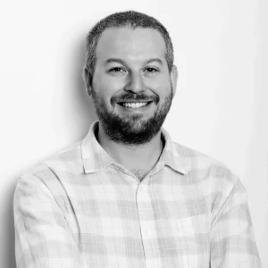 Smiling bearded man in plaid shirt, black and white photo