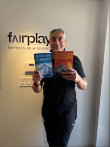 Man holding two books at Fairplay office
